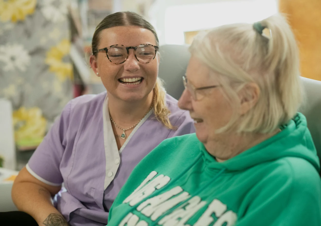 Two women smiling during a visit.