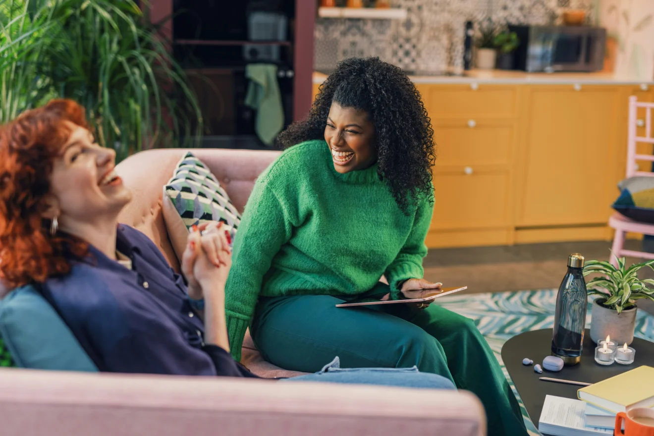 Two women sharing a conversation and a tablet.